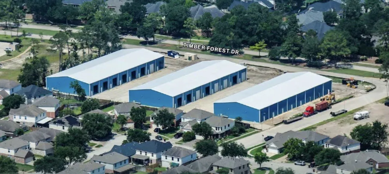 Aerial view of the three buildings from the north, with Timber Forest Drive running past the front of the property.