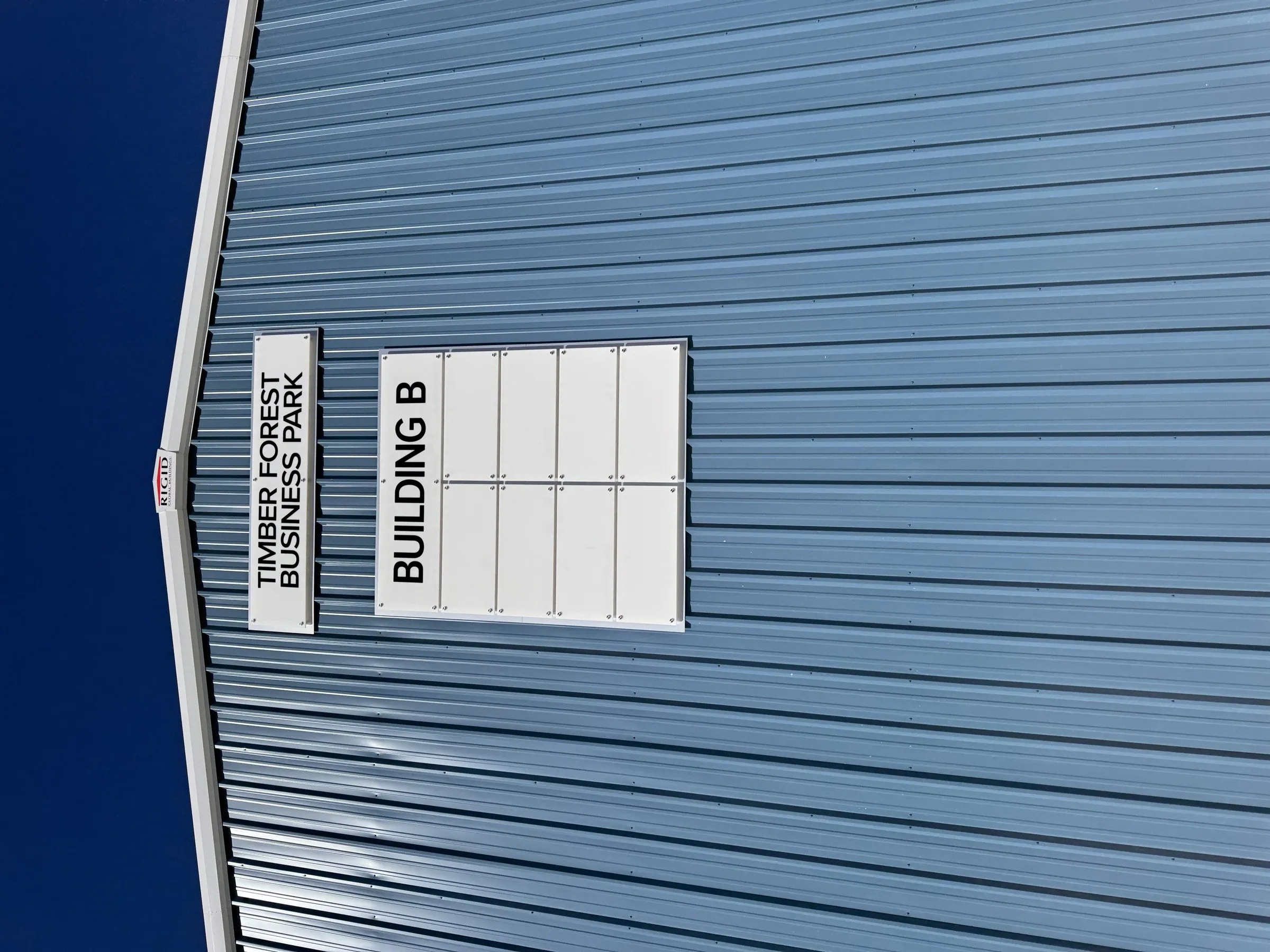 Timber Forest Business Park signage mounted on the metal wall of Building B.