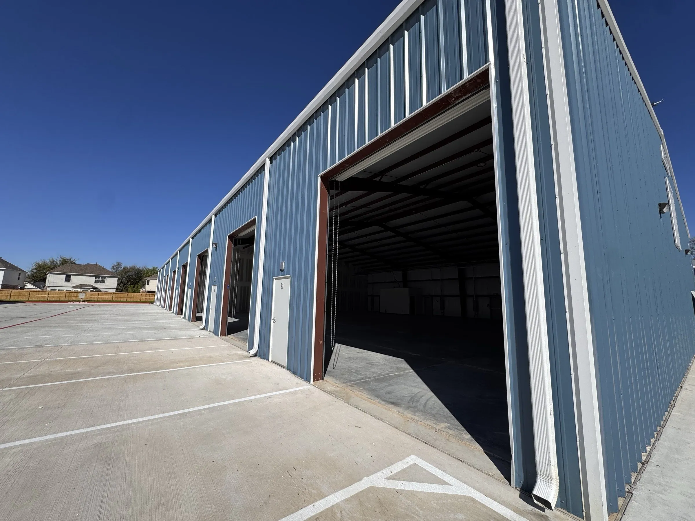 An open roll-up door seen from outside, showing the height of the opening against the building.