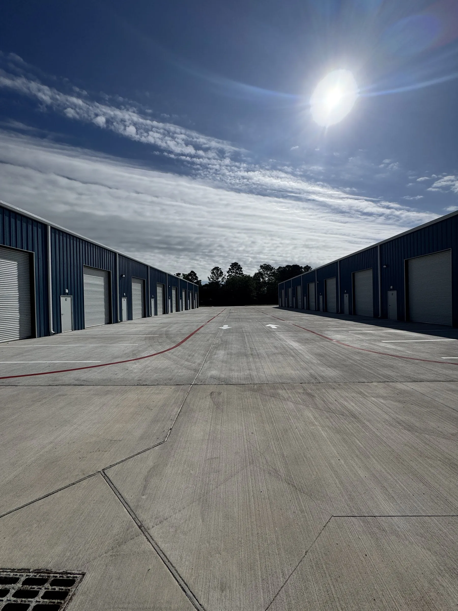 The concrete drive aisle between two of the buildings, wide enough to turn a truck.