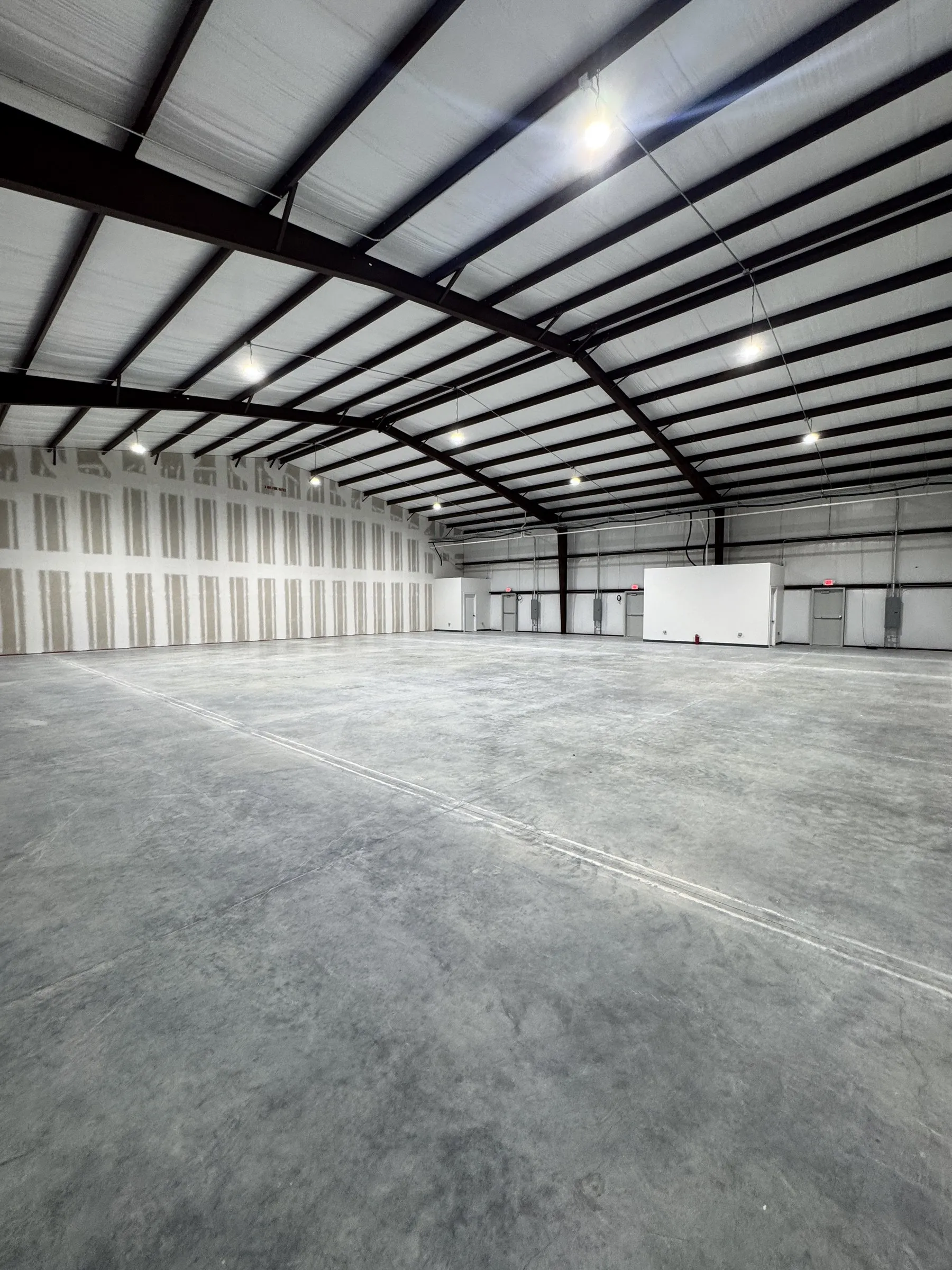 The same combined space with the overhead lighting on, showing the full width of the clear span.