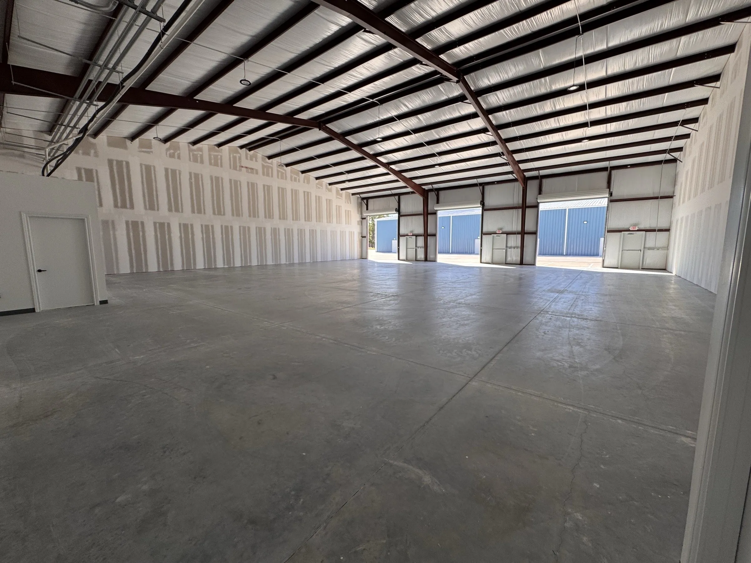 A bay seen from the back wall towards the roll-up door and man door at the front.